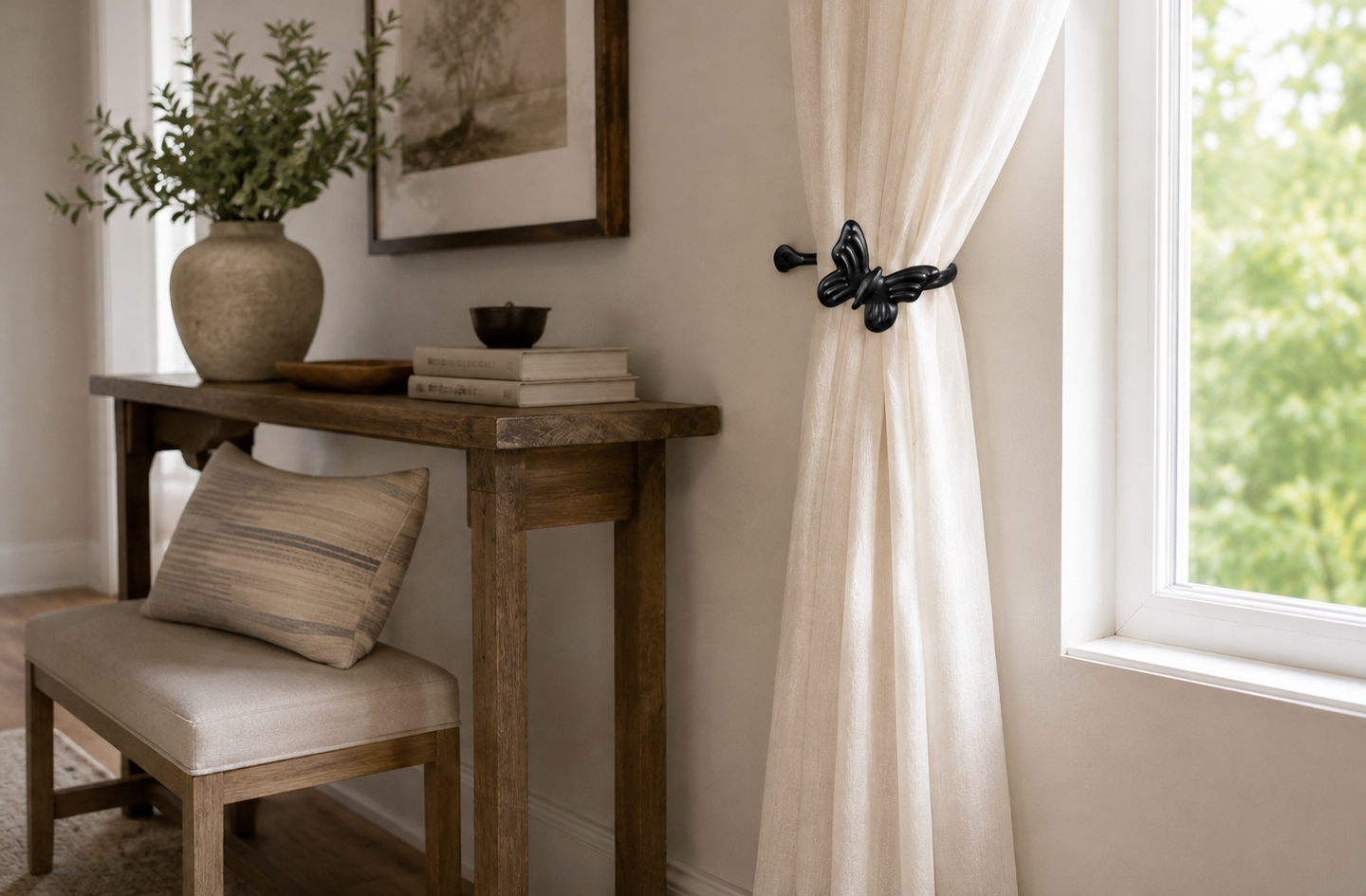 RTZEN black wrought iron butterfly curtain holdback securing a sheer white curtain beside a wooden console table with decorative items