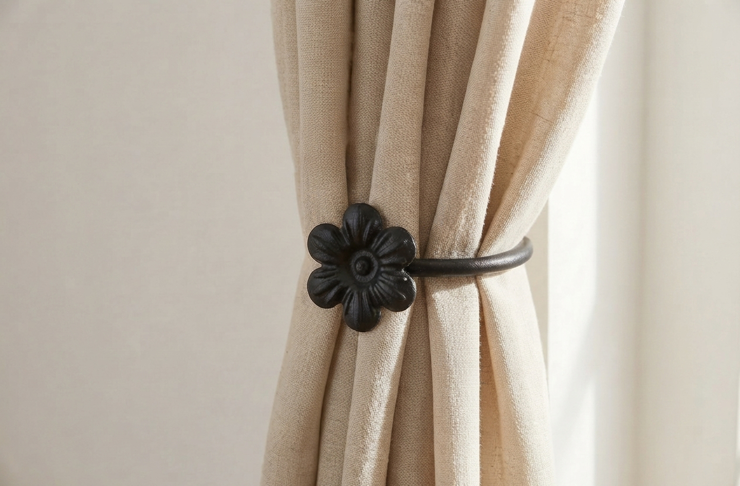 RTZEN black wrought iron flower curtain tie back hooks securing a beige linen curtain at a sunlit window